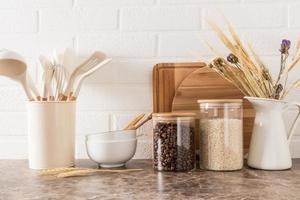 a set of kitchen utensils on a dark marble countertop against a white brick wall. interior background of the kitchen. photo