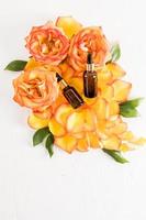 two bottles with a pipette with a rejuvenating face and body care product. natural cosmetics. top view. flat lay. a background of rose petals. photo