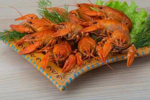 Boiled crayfish in a bowl on wooden background photo