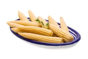 Baby corn in a bowl on white background photo