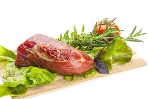 Smoked beef on wooden board and white background photo