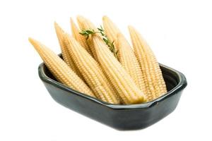 Baby corn in a bowl on white background photo