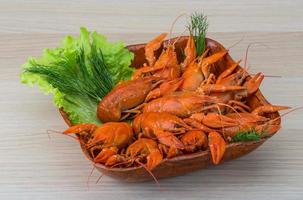 Boiled crayfish in a bowl on wooden background photo