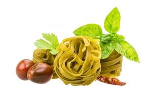 Green tagliatelle on white background photo