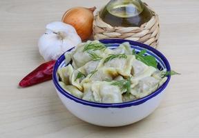 Ravioli in a bowl on wooden background photo