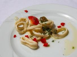 anillos de calamar en el plato y fondo blanco foto