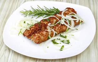 Kebab on the plate and wooden background photo