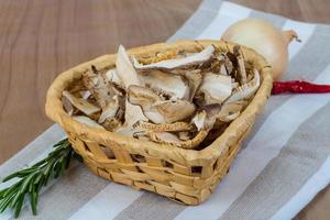 shiitake seco en una cesta sobre fondo de madera foto