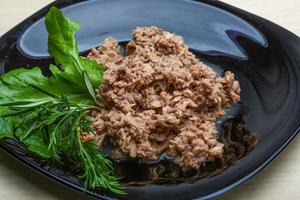 Cannded runa on the plate and wooden background photo