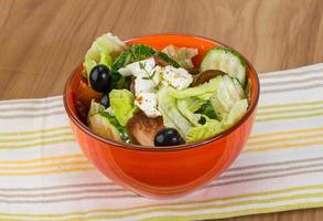 Greek salad in a bowl on wooden background photo