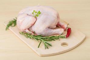 Raw chicken on wooden board and wooden background photo