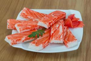 Crab sticks on the plate and wooden background photo