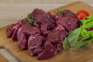 Raw venison on wooden board and wooden background photo