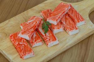 Crab sticks on wooden board and wooden background photo