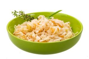 Fermented cabbage in a bowl on white background photo