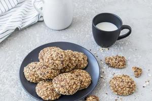 delicious healthy breakfast. oatmeal homemade cookies on a plate with a cup of fresh milk. photo