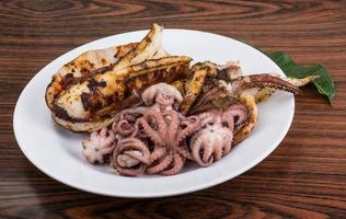 pulpo hervido en el plato y fondo de madera foto