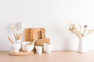 elegante fondo de cocina blanco con utensilios y flores secas en una jarra. Interior en colores claros. cocina ecológicamente limpia. foto