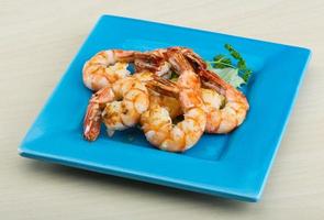 Tiger shrimps on the plate and wooden background photo