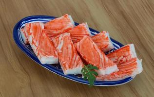 Crab sticks in a bowl on wooden background photo