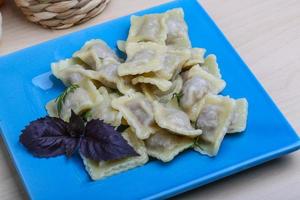 Ravioli on the plate and wooden background photo