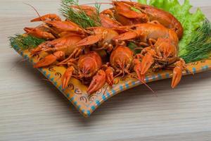 Boiled crayfish in a bowl on wooden background photo