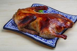 Roasted duck on the plate and wooden background