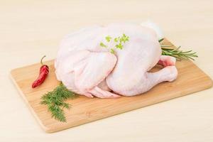 Raw chicken on wooden board and wooden background photo