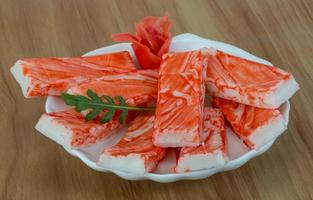 Crab sticks in a bowl on wooden background photo