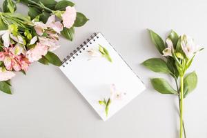 Blank notepad with white sheets for your text on a light background with spring colors. top view. congratulations on the holidays. photo
