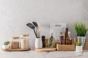 environmentally friendly items of modern dishes on the kitchen countertop made of white marble. stylish kitchen decor in light colours. photo