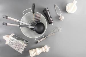 a set of various kitchen utensils made of metal and ceramics on a gray background. top view. flat layout. a copy of the space. photo