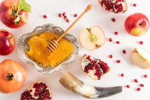 the top view of the traditional symbols of the celebration of the Roshashana honey, ripe apples, pomegranates and a cornucopia. photo