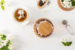 tea time. teapot with jasmine aromatic jasmine tea and a white cup of hot drink. top view. white background. photo