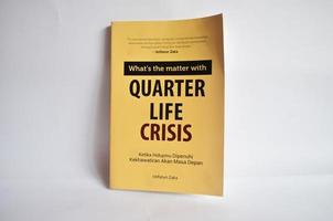 Blitar, Indonesia - October 9th 2022 A book with the title Quarter Life Crisis by Istifatun Zaka which contains worries about life. Elegant yellow cover book and isolated on white background photo