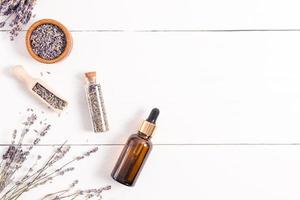 cosmetic organic lavender products for body skin care in glass bottles. top view. flat layout. a copy of the space. white wooden background. photo