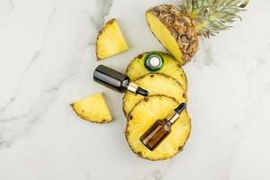 lifting serum with pineapple extract for face and hair care with the effect of deep moisturizing and nutrition in cosmetic bottles. top view. photo