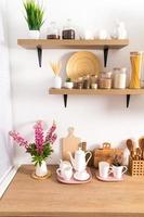 part of the interior of the modern kitchen . open shelves with various jars and countertop with kitchen utensils. ecologically clean kitchen. photo