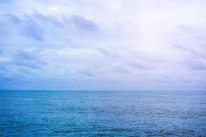 vacío de nubes blancas en el cielo azul sobre el mar en calma con espacio de copia para banner o fondo de papel tapiz. concepto de paisaje marino foto