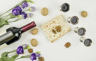 the concept of the Passover holiday. Pesah. top view of matzah, silver glasses with red wine, a bottle of wine, walnuts. photo