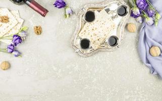 the concept of celebrating Passover. Jewish holiday Passover.matzah, silver glasses with wine on a tray, purple flowers. photo