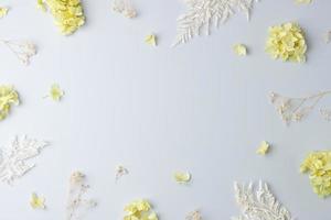 Cosmetic background with flowers on grey. Flat lay, copy space photo