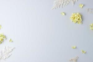 Cosmetic background with flowers on grey. Flat lay, copy space photo