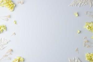 Cosmetic background with flowers on grey. Flat lay, copy space photo