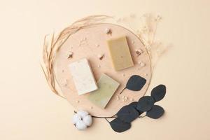 Soap with flowers on pastel beige background. Flat lay, copy space. photo