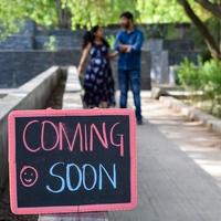 pareja india posando para una sesión de fotos de maternidad. la pareja está posando en un césped con hierba verde y la mujer está faluntando su panza en el jardín lodhi en nueva delhi, india