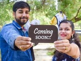 pareja india posando para una sesión de fotos de maternidad. la pareja está posando en un césped con hierba verde y la mujer está faluntando su panza en el jardín lodhi en nueva delhi, india