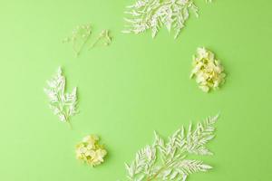 Cosmetic background with flowers on green. Flat lay, copy space photo
