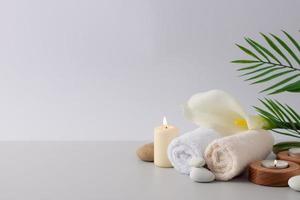 Spa treatment with candles, towel and flowers on white background. Close up, copy space photo