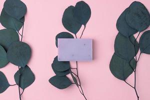 Soap with eucalyptus on pink natural background. Flat lay, copy space. photo